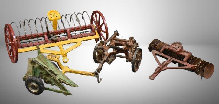 (4) cast iron toy implements: 2-botttom plow (arcade), corn sheller (arcade), disc (arcade) & hay rake (Kenton?, larger)