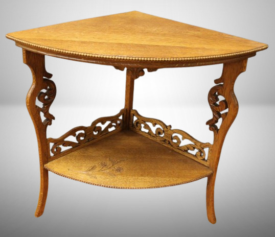 Oak corner parlor table w/ ornate carved legs and supports, etched flower on lower shelf