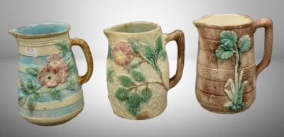 (3) Majolica 6" milk pitchers, all w/ plant or floral decorations