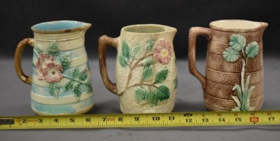 (3) Majolica 6" milk pitchers, all w/ plant or floral decorations - 11