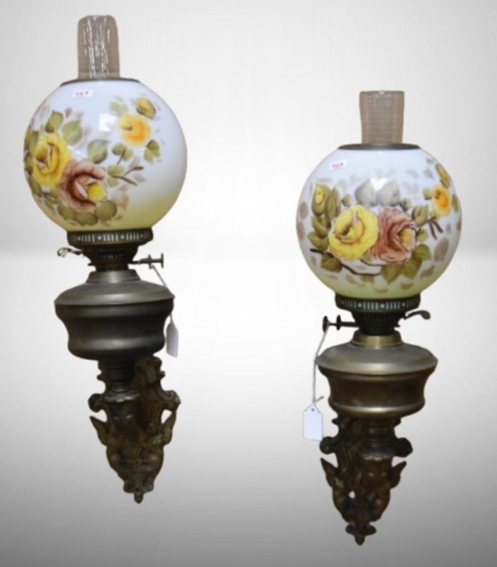 Pair of Cast Iron wall mount kerosene lamp holders with handpainted floral shades, brackets have heavily embossed designs