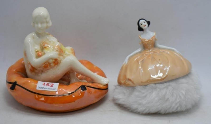 (2) Porcelain figural items: 3.5"h ballerina powder puff; 4" nude girl sitting on pillow (was a powder box lid but use as a decorative vanity item)